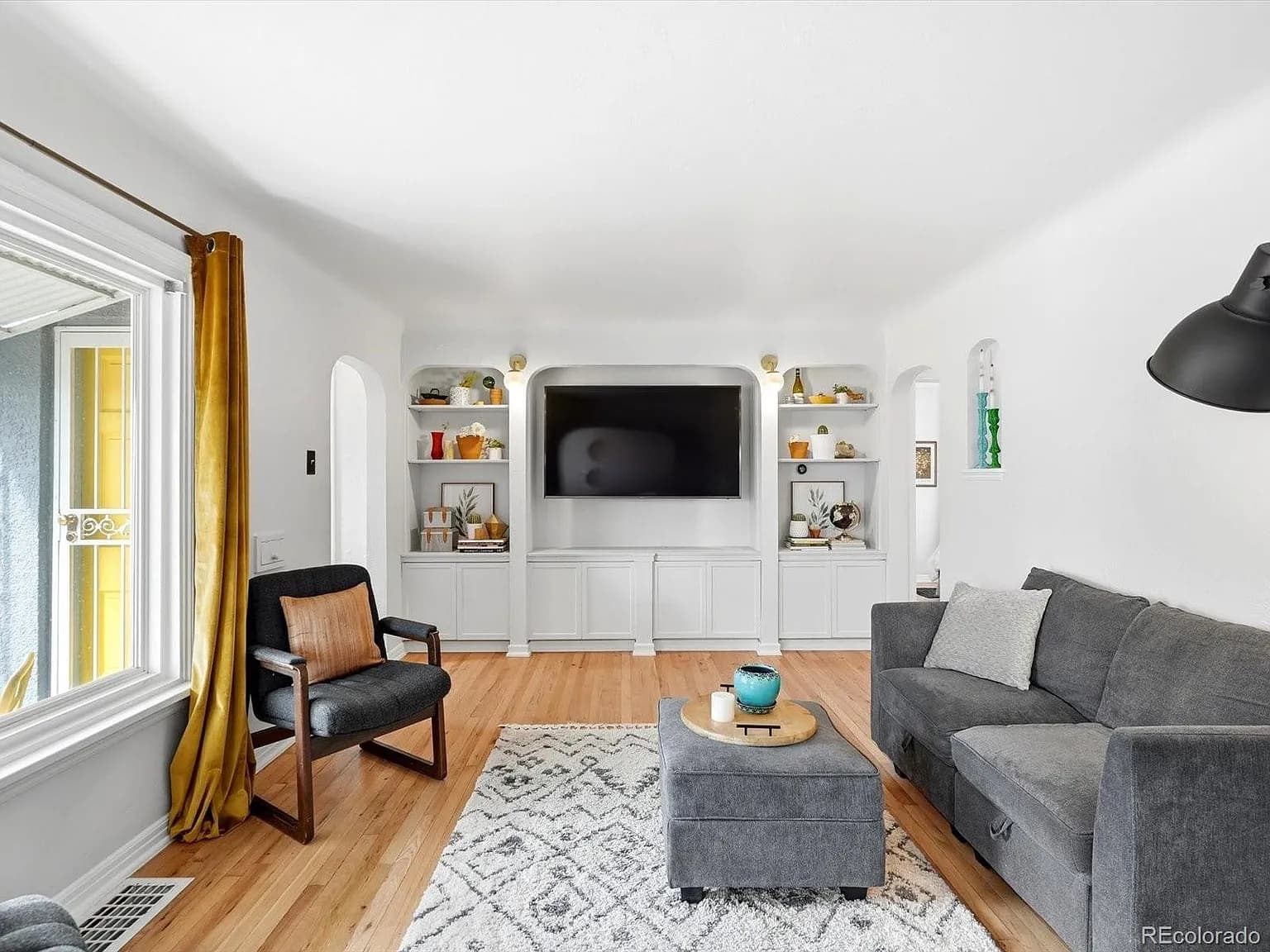 Living room with built-in cabinets, shelving, and entertainment center