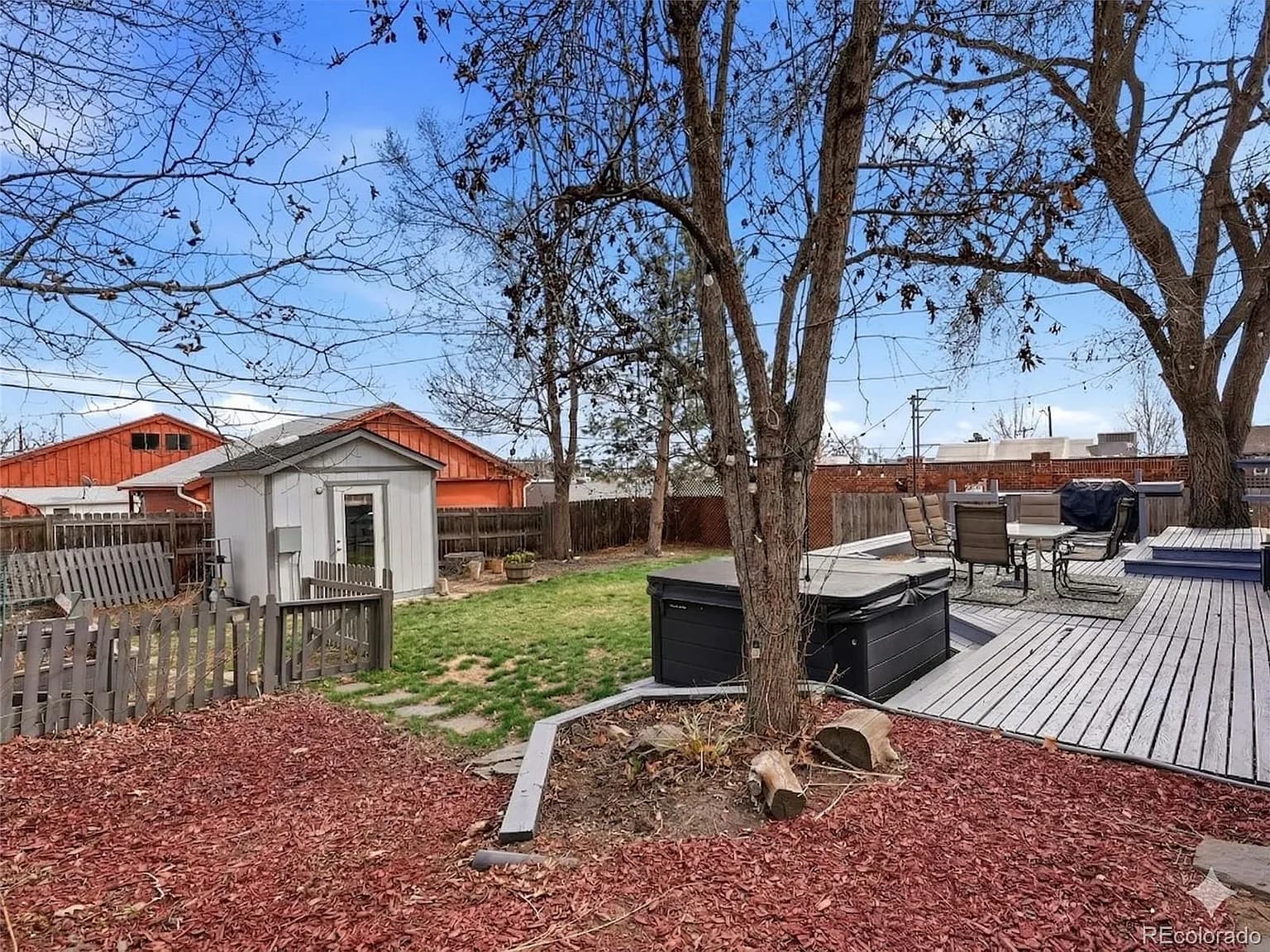 Backyard with storage shed, fire pit area, and mature trees