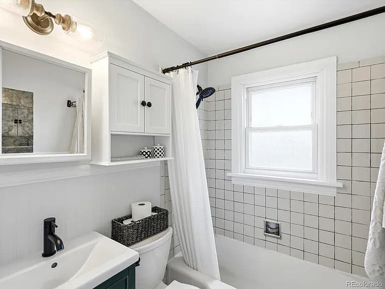Updated main bathroom with tile shower and beadboard wainscoting