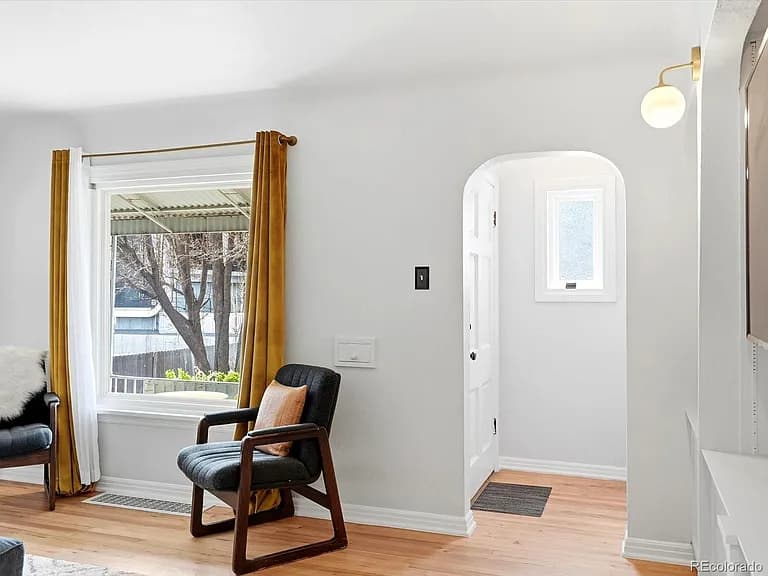 Living room detail showing arched entryway, foyer, and gold curtains