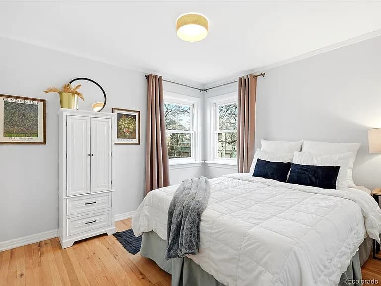 Primary bedroom with bay window and hardwood floors
